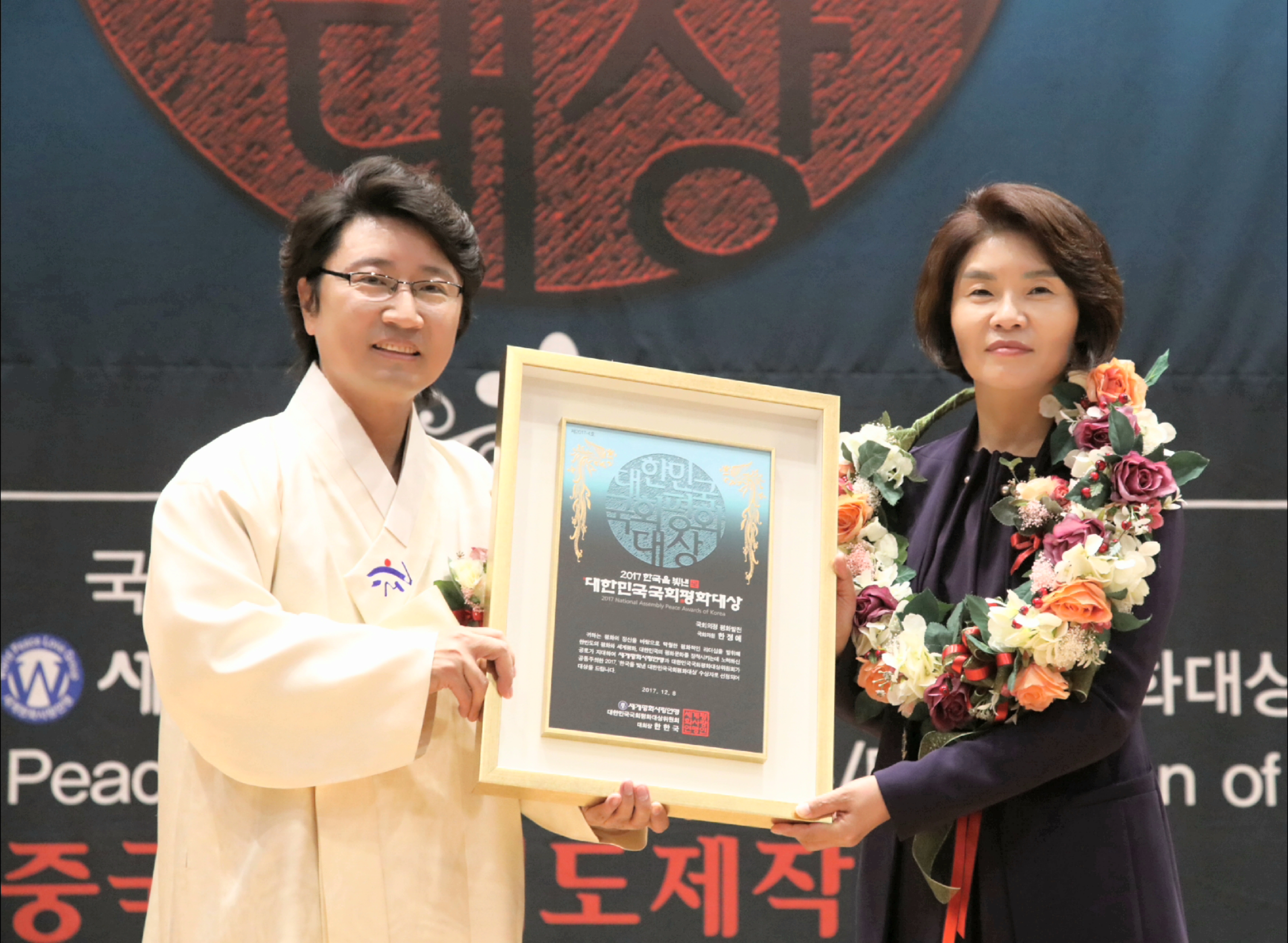 한한국(세계평화사랑연맹 이사장)대회장이 한정애(국회의정 평화발전부문)국회의원에게 시상을 하고 기념촬영을 하고 있다(사진=세계평화사랑연맹~